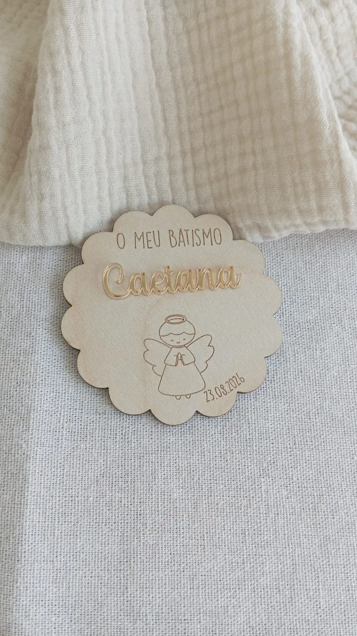 Íman de madeira recortado, com o nome Caetana em acrílico dourado espelhado e um anjo gravado