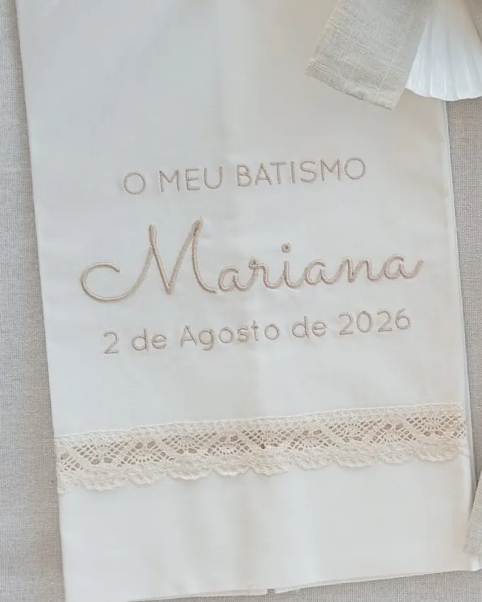 Toalha de batismo bordada com «O meu batismo», o nome Mariana e a data, com renda